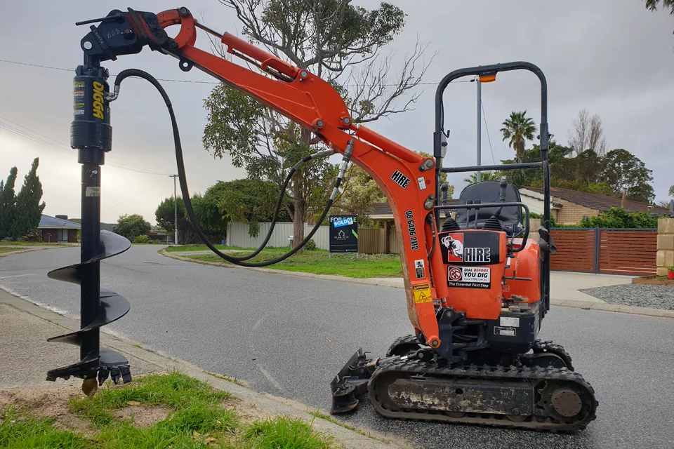 Mini excavator with auger attachment