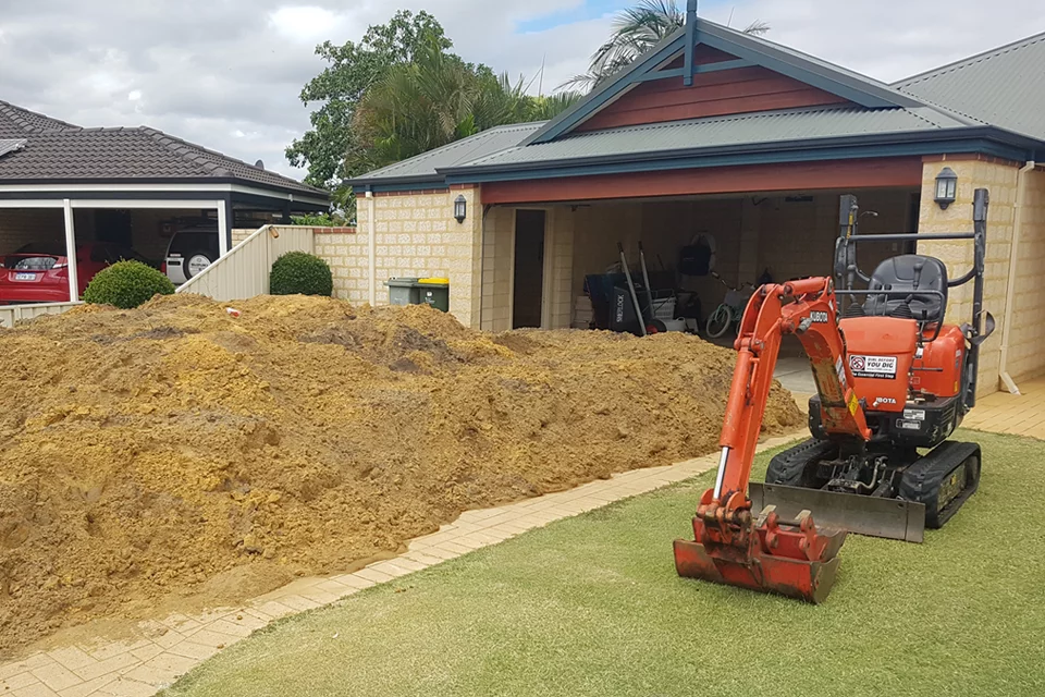 Mini excavator excavating sand.