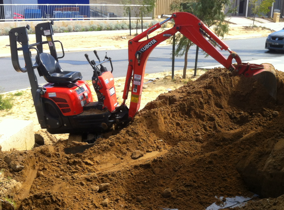 Mini excavator excavating sand