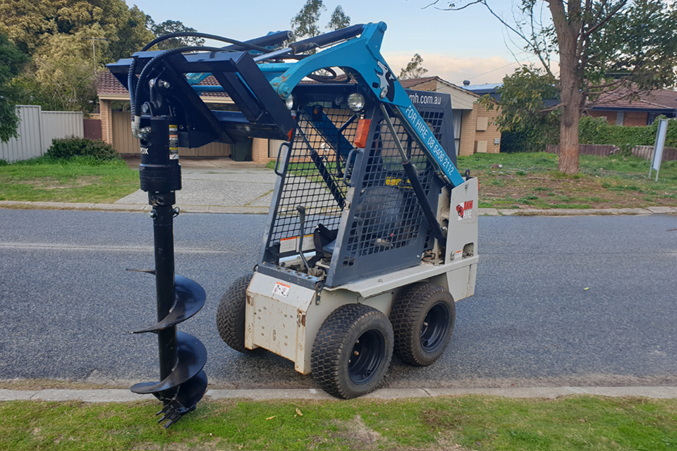 Skid steer with auger attachment