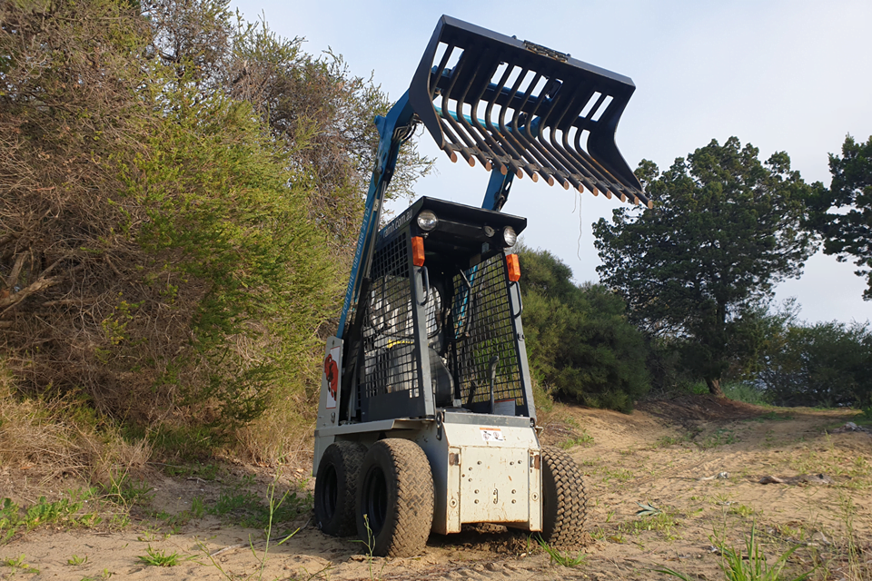 Skid steer with rake bucket